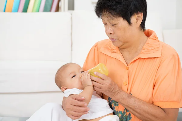 Babysitter mamadeira alimentação bebê — Fotografia de Stock