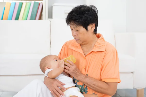 Nanny bottle feeding baby — Stock Photo, Image