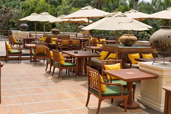 Tables with umbrellas in tropics — Stock Photo, Image