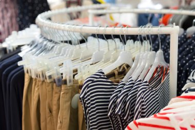 Mağazadaki askılarda asılı giysiler