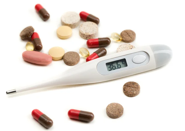 Electronic thermometer and tablets — Stock Photo, Image