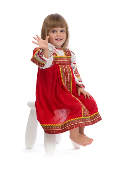 Klein meisje in rood traditionele kleding op een stoel — Stockfoto