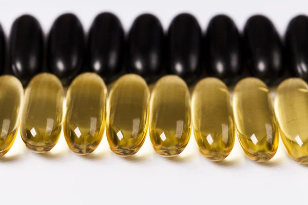 Black and yellow capsules — Stock Photo, Image