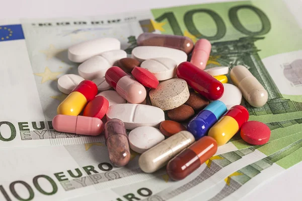 Medicine tablets on money — Stock Photo, Image