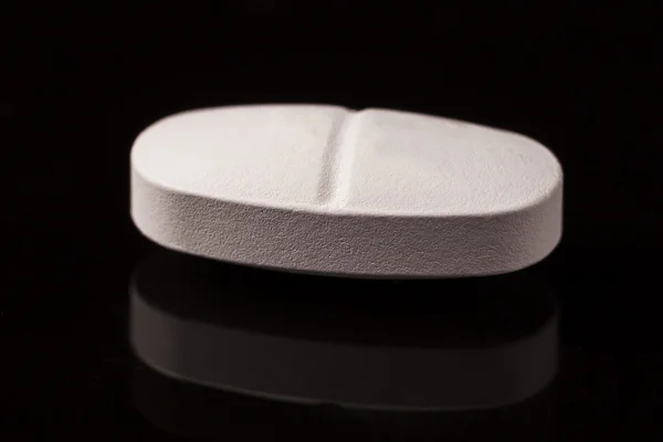黒い背景に白い錠剤 — ストック写真