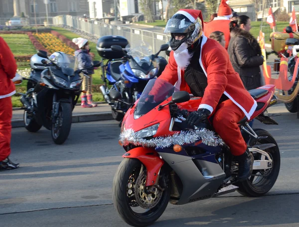 Santa Claus no definido entrega ayuda humanitaria en forma de regalos a niños discapacitados durante el desfile anual de motocicletas de Santa Claus el 26 de diciembre de 2015 en Belgrado, Serbia —  Fotos de Stock