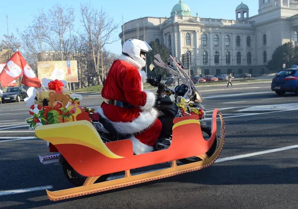 Undefinierter Weihnachtsmann, der während der jährlichen Motorradparade des Weihnachtsmannes am 26. Dezember 2015 in Belgrad, Serbien, humanitäre Hilfe in Form von Geschenken an behinderte Kinder leistet — Stockfoto