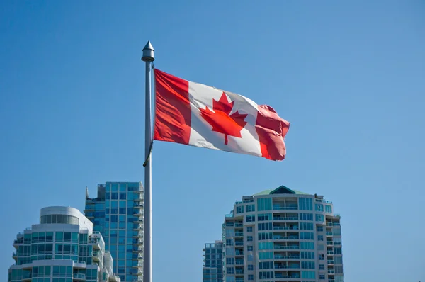 Bandera canadiense en los rascacielos de Vancouver Imagen de archivo