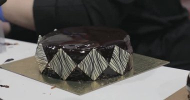 Pasta şefi fondant dekorasyonlu yuvarlak çikolatalı kek yapıyor.