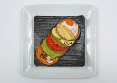 Top Plate View 'da servis edilen çift katlı bıldırcın yumurtalı hamburger.