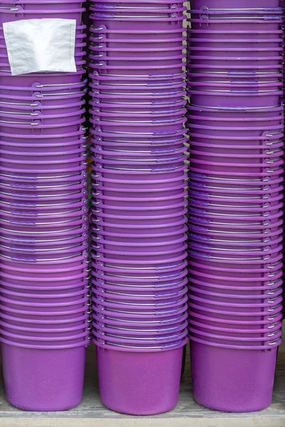 Big Stack of Many Purple Plastic Buckets