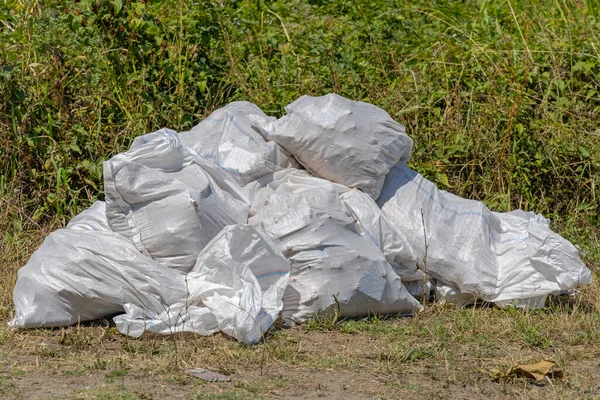 大自然中的一大捆白麻袋垃圾 — 图库照片