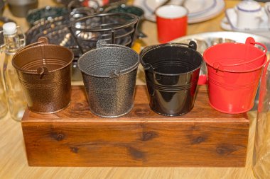 Tahta Tablo Bloğunda Farklı Renklerde Dört Küçük Metal Kova