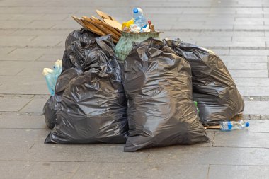 Şehir Caddesinde atık dolu siyah çöp torbaları