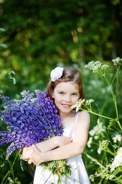 Schönes Mädchen mit Lupinen lizenzfreie Stockbilder