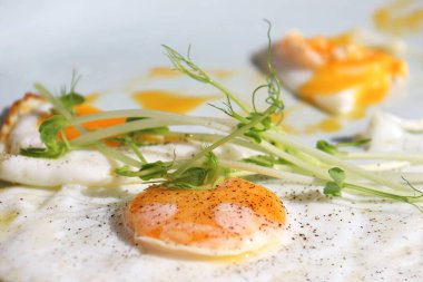 Kızarmış, güneşli, yeşil garnitürlü ve karabiberli yumurtalar..