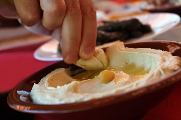 Uomo Che Immerge Una Fetta Pane Pita Piatto Hummus Tradizionale — Foto Stock