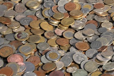 Çeşitli ülkelerden gelen ve farklı para birimleri, semboller, dokular ve metalik tonlarda sergilenen çeşitli madeni paraların yakın çekimleri.