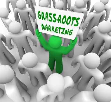 A man holding a Grass Roots Marketing sign in a crowd clipart