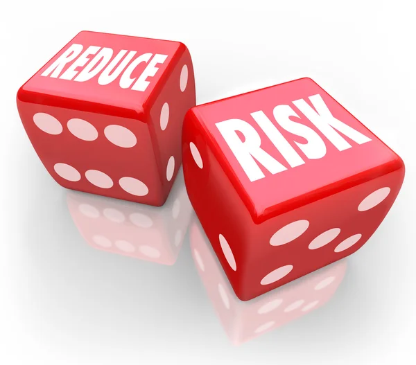 Reduzir palavras de risco em dois dados vermelhos — Fotografia de Stock