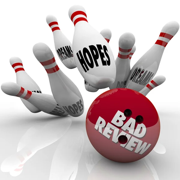 Dålig recension ord på ett bowlingklot slående pins — Stockfoto
