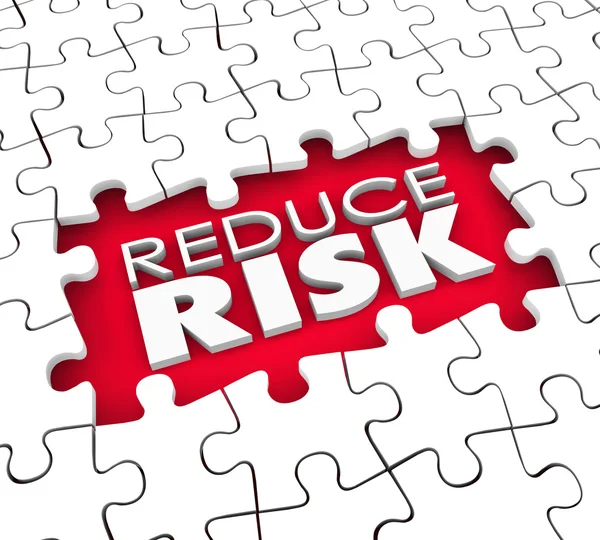 Reduce Risk words in the hold of a puzzle — Stock Photo, Image