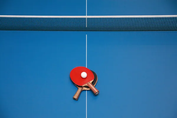 Raquetes e bola na mesa de tênis — Fotografia de Stock