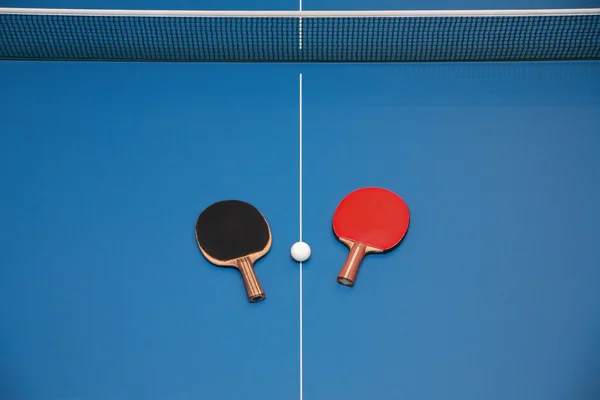Raquetes e bola na mesa de tênis — Fotografia de Stock
