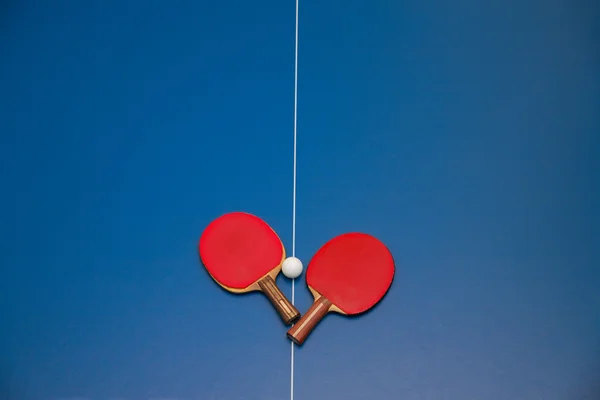 Rackets and ball on tennis table — Stock Photo, Image