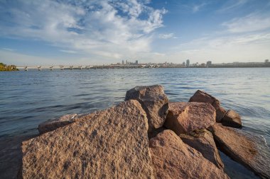 Dnepropetrovsk, şehrin manzarası, Dinyeper kıyılarındaki merkez ve merkez köprü, ön planda granit taşlar.