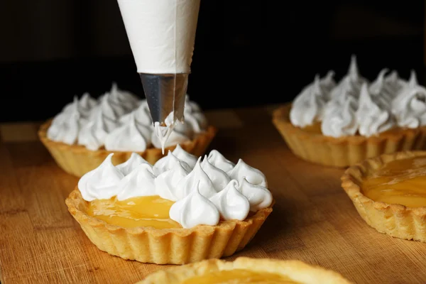 Finom citromos túró tartlets a meringue a fából készült asztal Stock Fotó