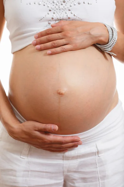 Gros plan d'un ventre d'une femme enceinte avec les mains touchant — Photo