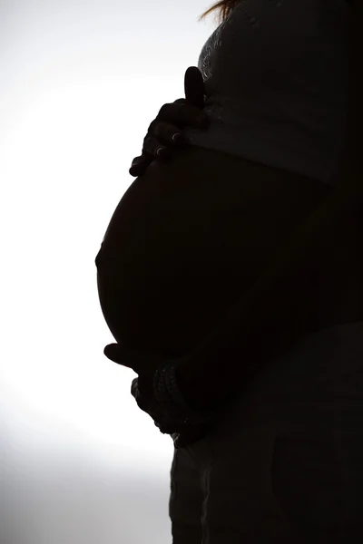 Femme enceinte méconnaissable avec les mains sur le ventre noir et blanc — Photo