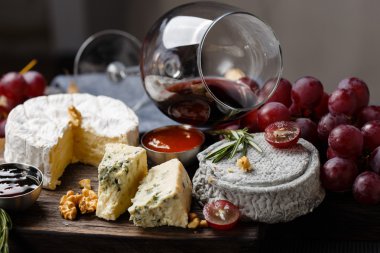 Cheese plate served with wine, jam and honey clipart