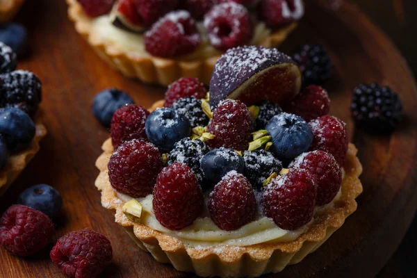 Tartlets com bagas frescas em fundo de madeira — Fotografia de Stock