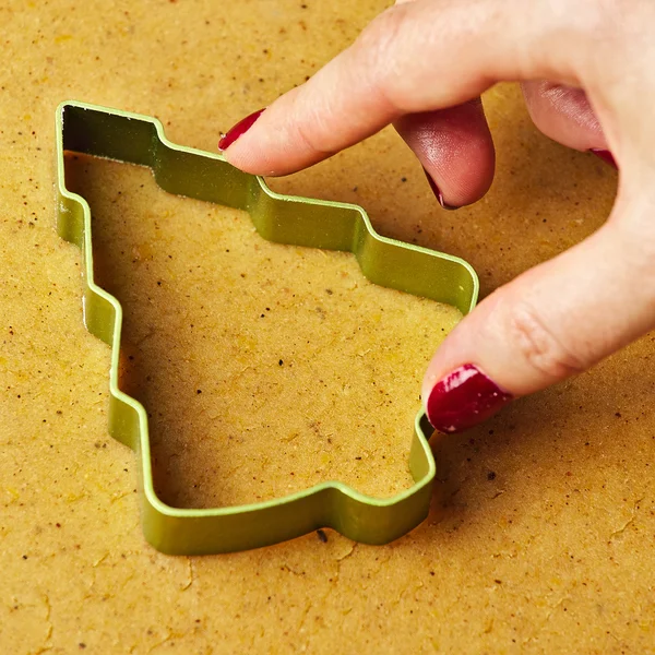 Жіноча рука робить різдвяну ялинку імбирним печивом — стокове фото