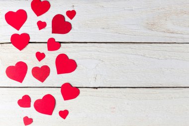Beyaz ahşap arka plan üzerinde kırmızı kalp kağıt kesme.
