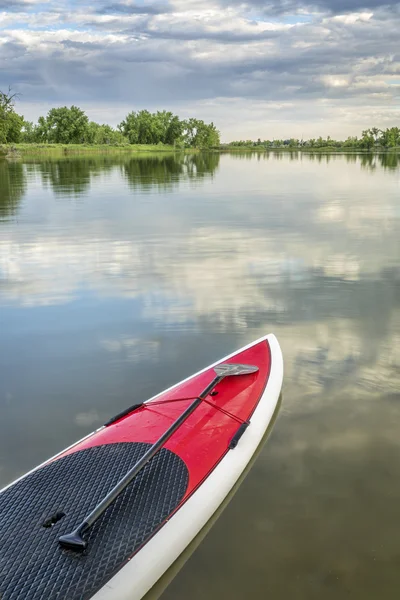 Wstać paddleboard na spokojnych wodach jeziora — Zdjęcie stockowe