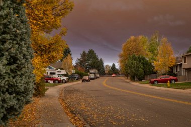 Fort Collins, CO, ABD - 22 Ekim 2020: Dağlık orman yangınından kaynaklanan yoğun duman bulutu altındaki bir yerleşim yerinin öğle vakti manzarası - sağlıksız hava kirliliği seviyeleri,