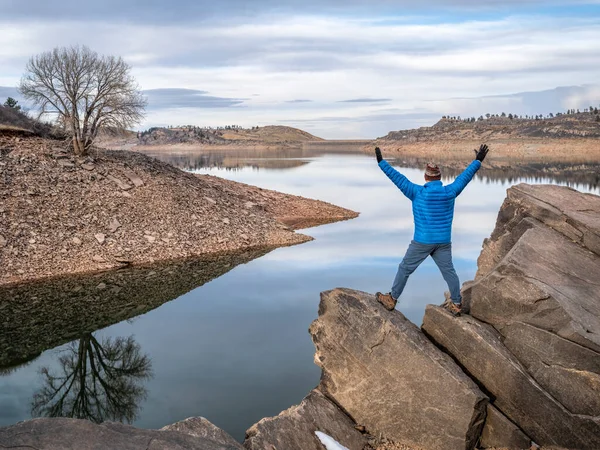 ロッキー山脈の麓にある山の湖の岩場の海岸で幸せな男性ハイカー Horsetooth貯水池 秋や冬の風景でコロラド北部の人気のレクリエーションエリア — ストック写真