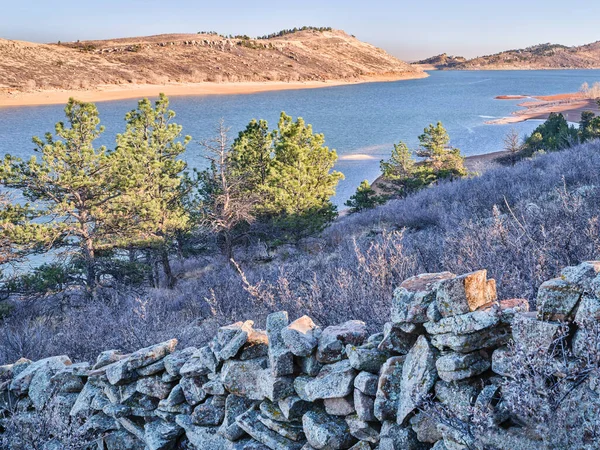 ホーストース貯水池の上のロッキー山脈の麓にある古い石の柵 低水位で北コロラド 秋または冬の風景で人気のレクリエーションエリア — ストック写真