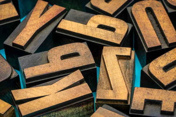 アルファベットのランダムな文字 トルコ石の手作りの紙に対するヴィンテージレタープレス木材タイプ — ストック写真