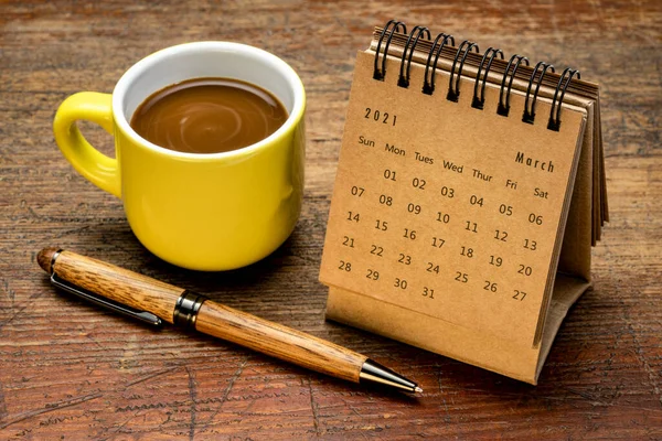 2021年3月 コーヒー ビジネスコンセプトの素朴な風化した木材に対するスパイラルデスクトップカレンダー — ストック写真