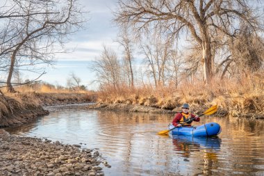 Son sınıf öğrencisi erkek, bahar başlarında Colorado 'nun kuzeyinde Poudre Nehri' nde şişme bir yük teknesinde kürek çekiyor.