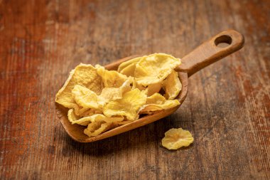 Kurumuş yat yumrusu dilimleri eskimiş odunlara karşı kırsal ahşap bir kepçe. Yacon inulin içerir, sağlıklı probiyotikleri teşvik eden karmaşık bir şeker. Süper yiyecek konsepti.