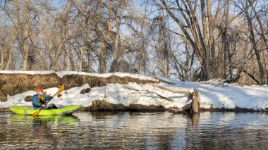 Yaşlı erkek kürekçi, Fort Collins, Colorado 'daki Poudre Nehri' nde küçük bir nehirde şişme su kayağı yapıyor.