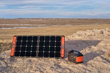 Nunn, CO, ABD - 28 Mart 2021: Jackery Explorer 500, 518W0lithium Portable Power Station, Pawnee Ulusal Çayırı 'nın uzak bir noktasında bir güneş paneli tarafından şarj ediliyor..