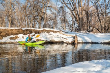 Yaşlı erkek kürekçi, Fort Collins, Colorado 'daki Poudre Nehri' nde küçük bir nehirde şişme su kayağı yapıyor.
