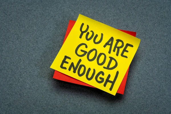 you are good enough inspirational concept - handwriting in black ink on a sticky note, positive affirmation, self confidence and personal development