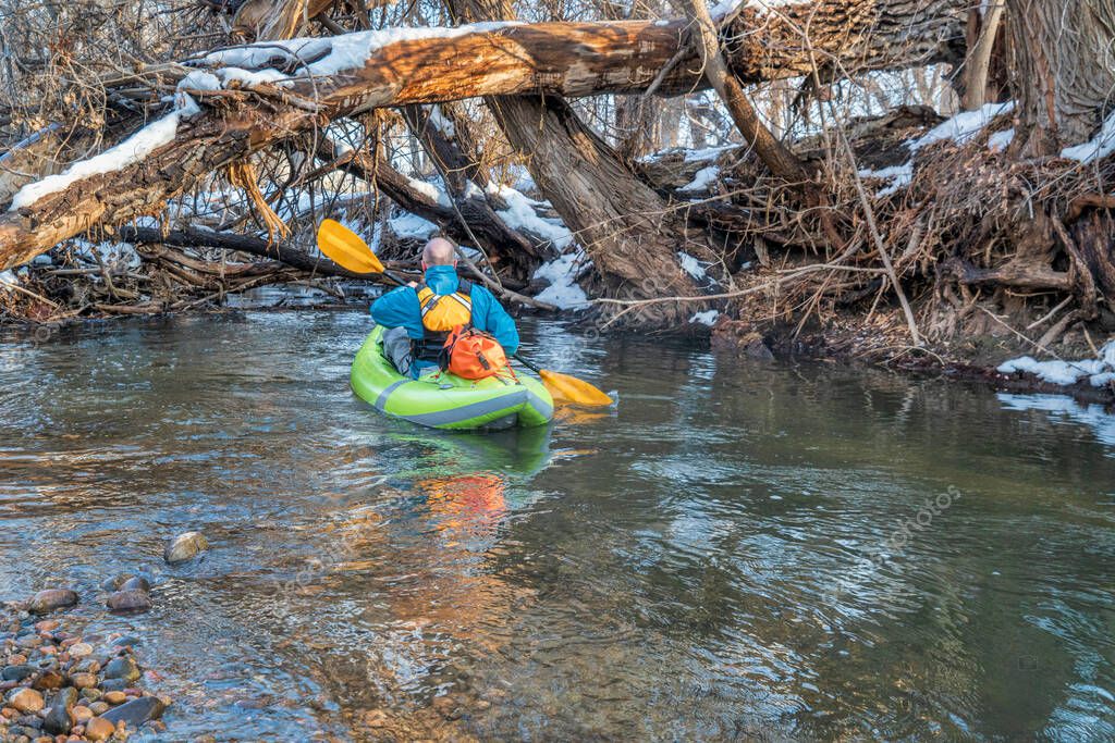 macho mayor está remando un kayak inflable de aguas bravas en el atasco